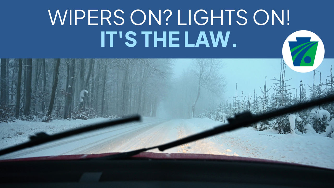  Photo of a snow-covered road through a car windshield with the wipers up