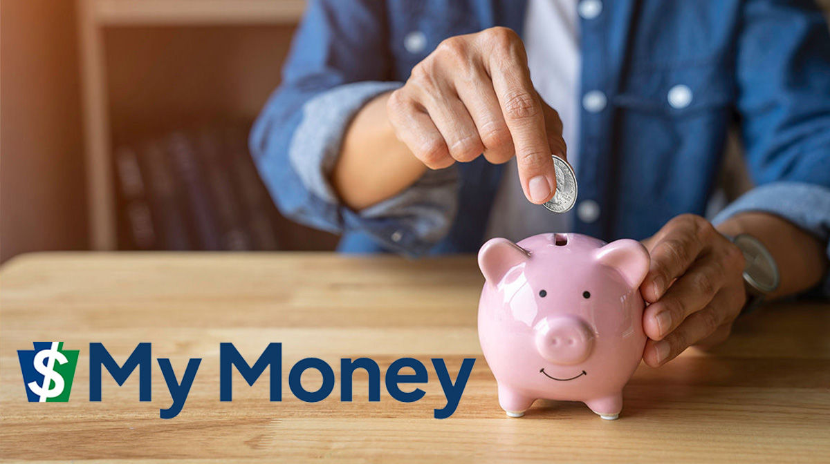 A person putting a quarter into a pink piggy bank