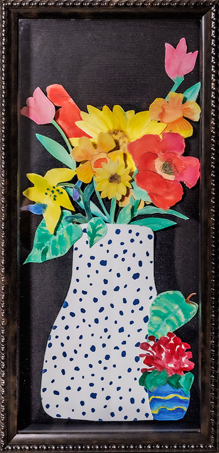 a vase with various painted and cut flowers