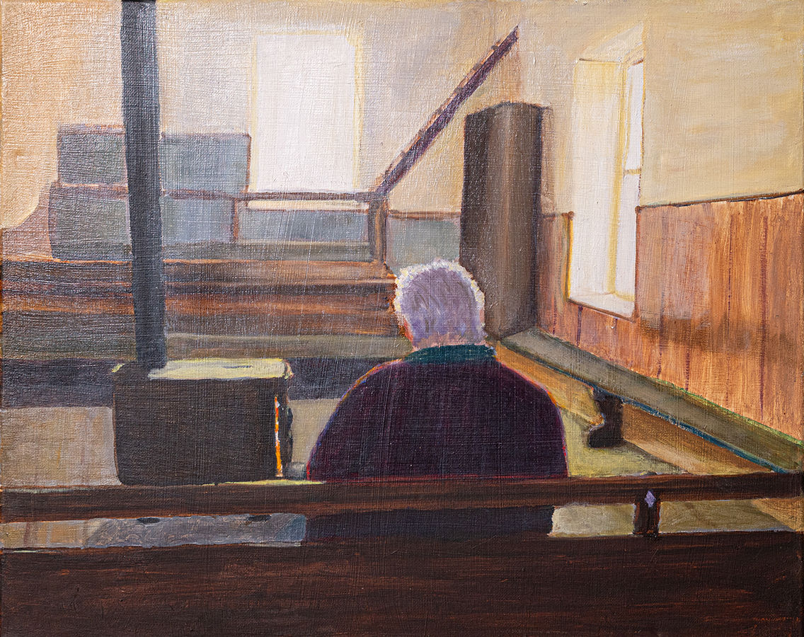 person sitting alone in meeting hall with stove