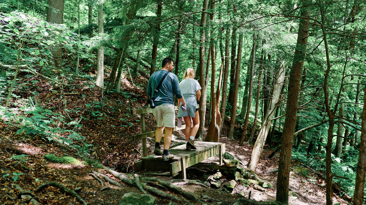 A man and woman hike in the Pennsylvania woods.