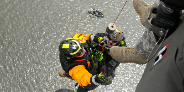 A Helicopter Aquatic Rescue Team member repels from a helicopter.