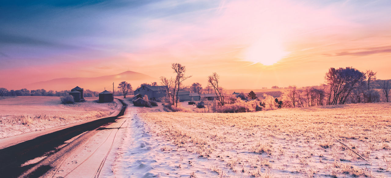 An orangey-pink sunset over a snowy, winter Pennsylvania landscape.