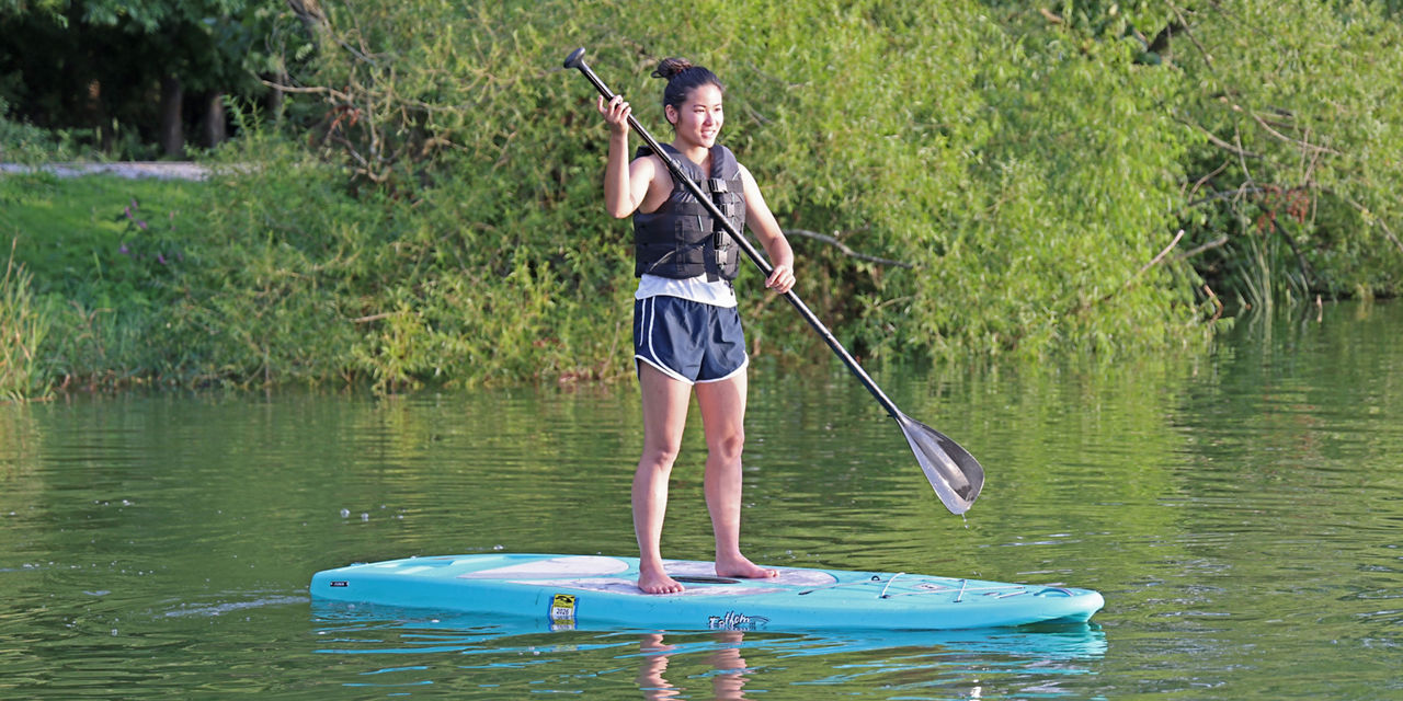 Woman shown wearing a life jacket on a paddleboard with a Launch Permit on Marsh Creek Lake