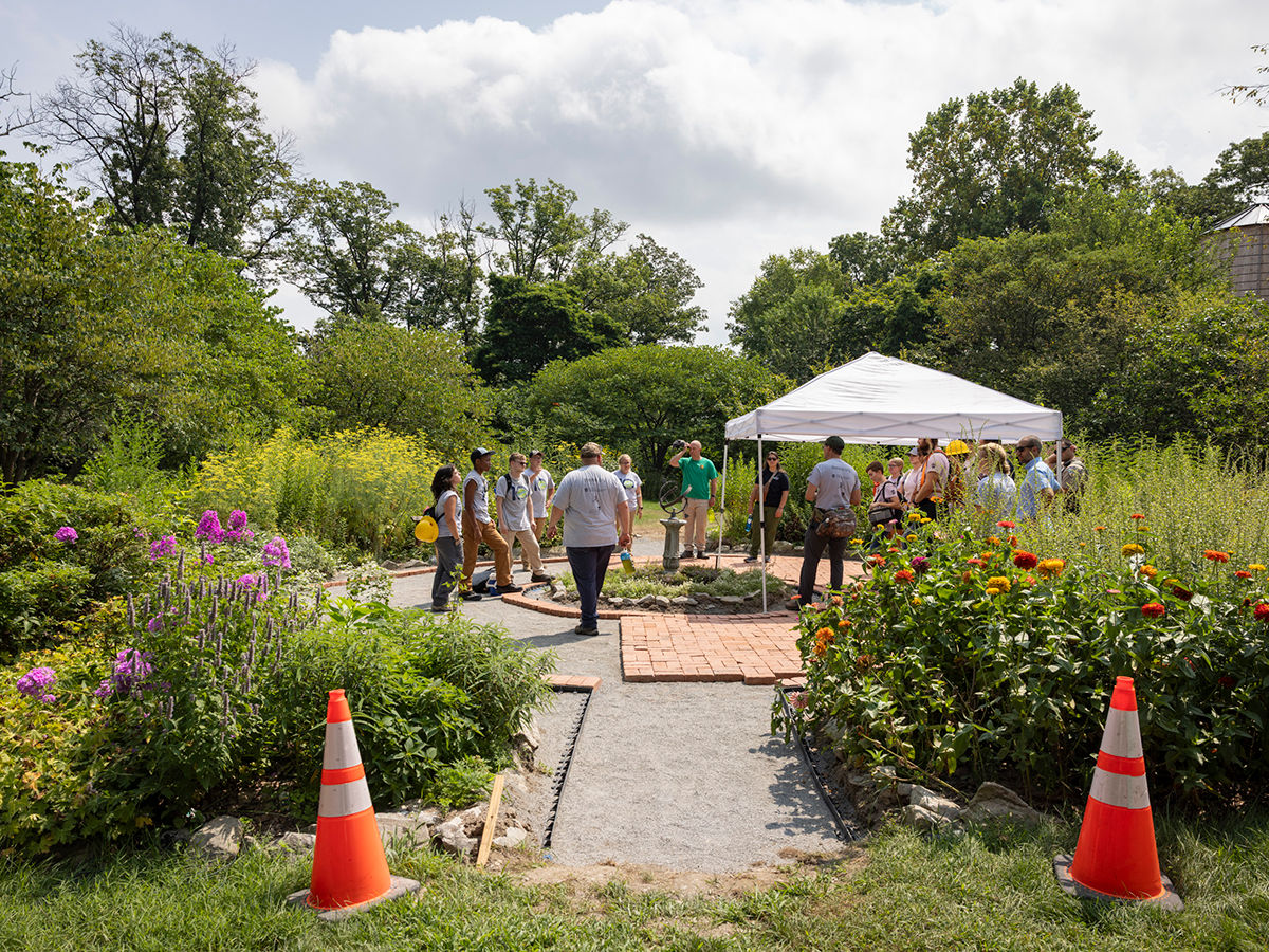 PA Outdoor Corps members work to complete an accessible brick path in a garden.