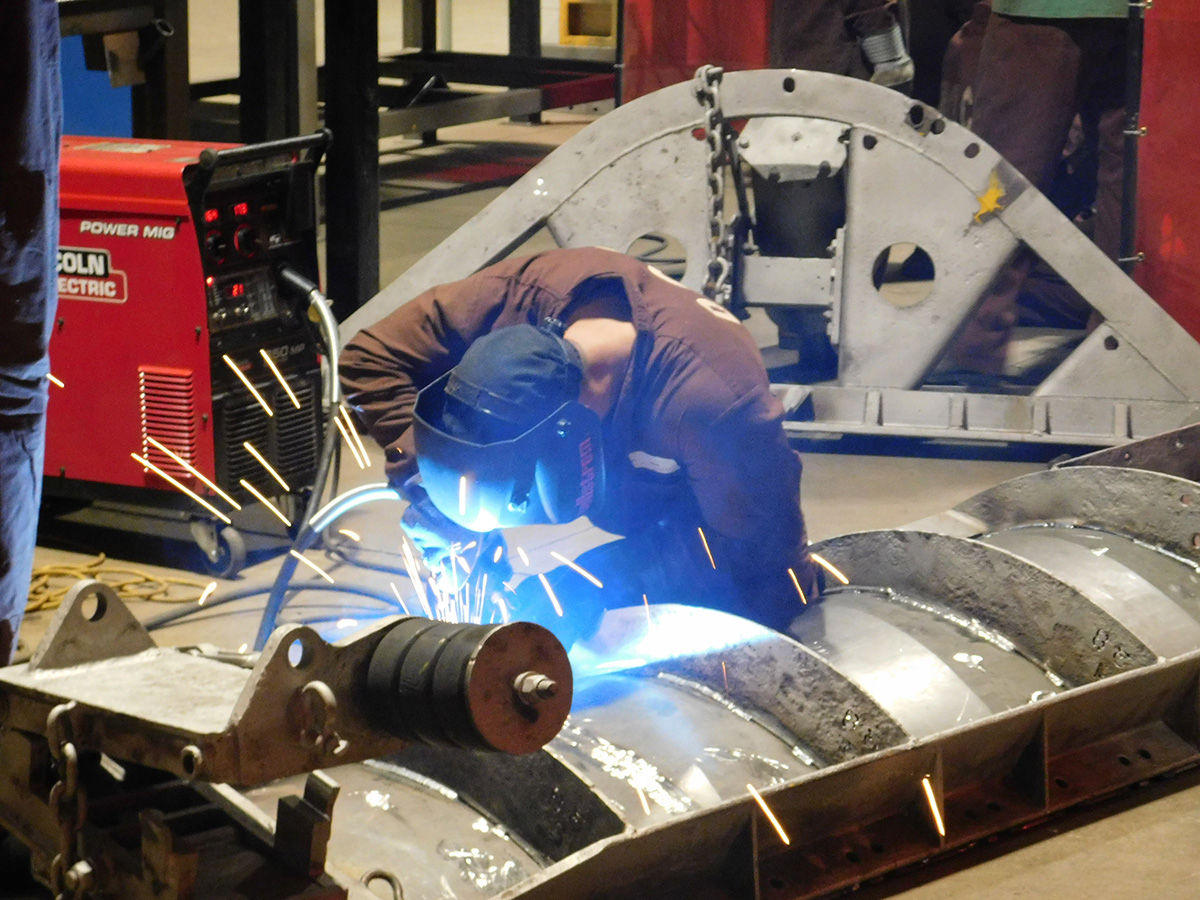 An inmate welds metal