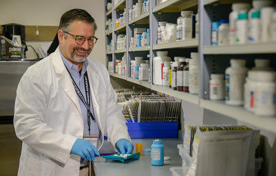 Pharmacist standing at a table counting pills