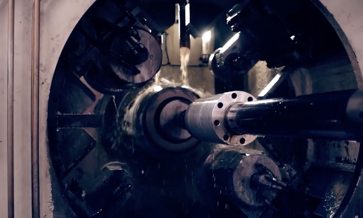A machine for precision metal forming spins a metal cylinder in its chamber.
