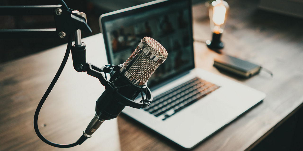 A microphone with a laptop in the background