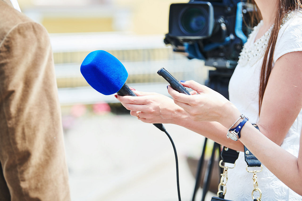 Reporters with microphones and cameras during an interview