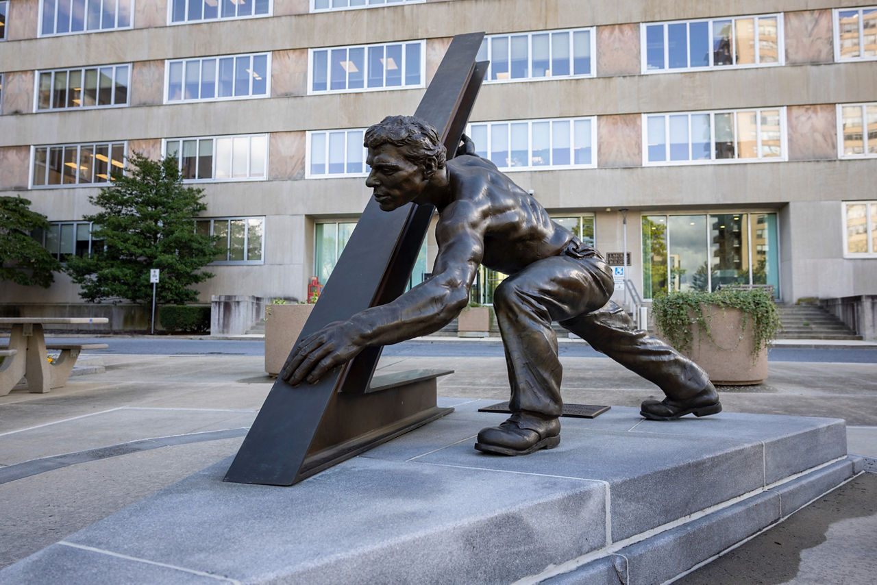 Image of 'The Pennsylvania Worker', a bronze sculpture honoring generations of Pennsylvanians whose skill, grit, and perseverance have built and continue to sustain the Commonwealth in front of the PA Labor and Industry Office Building in Harrisburg, PA.