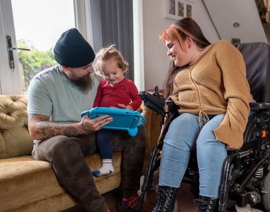 A family of three plays on an iPad.