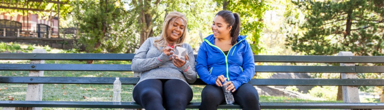 Two women on a bench looking at a phone