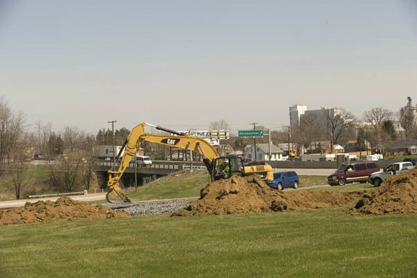 heavy equipment performs construction alongside a roadway