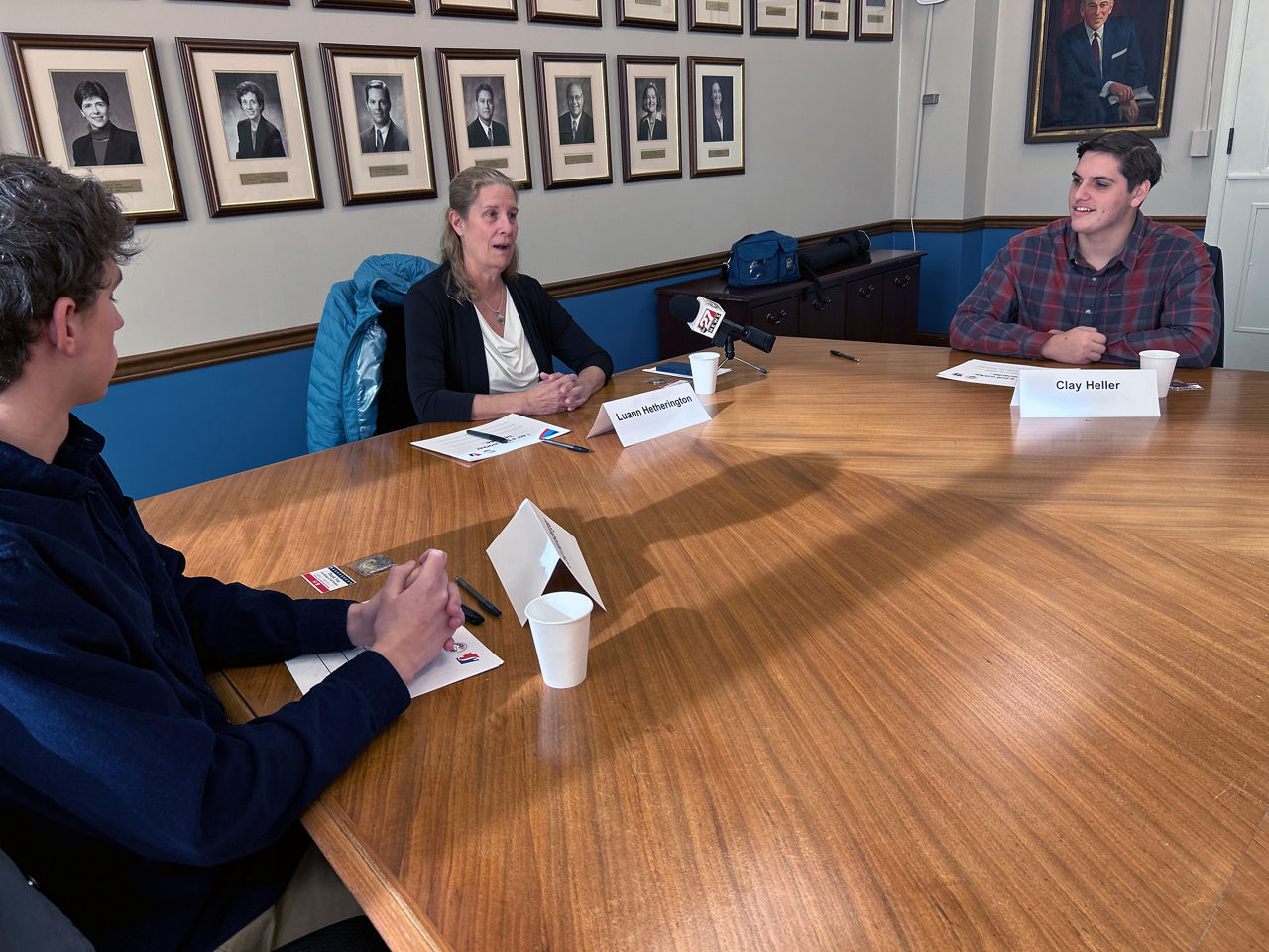 Luann Hetherington, center, head swim coach at Susquehanna Township High School and the judge of elections for the township’s Ward 4 precinct, speaks Friday during a student poll worker roundtable event in the Department of State’s conference room in Harrisburg. Hetherington and six of her current and former student poll workers spoke with Jonathan Marks, Deputy Secretary for Elections, for about an hour in advance of national Help America Vote Day, which is today (Jan. 27). Pictured with Hetherington are Cole Hunsberger, left, and Clay Heller, both seniors at Susquehanna Township High School.