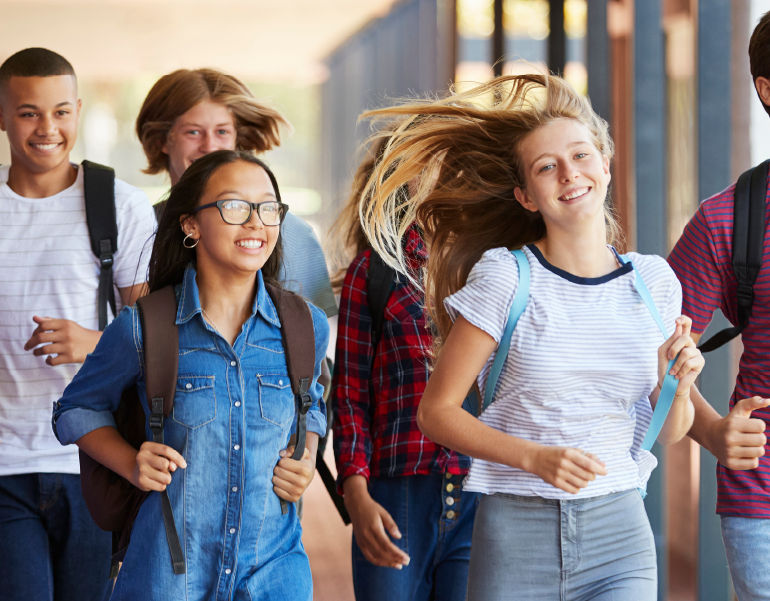 Happy students walk the halls of their school.