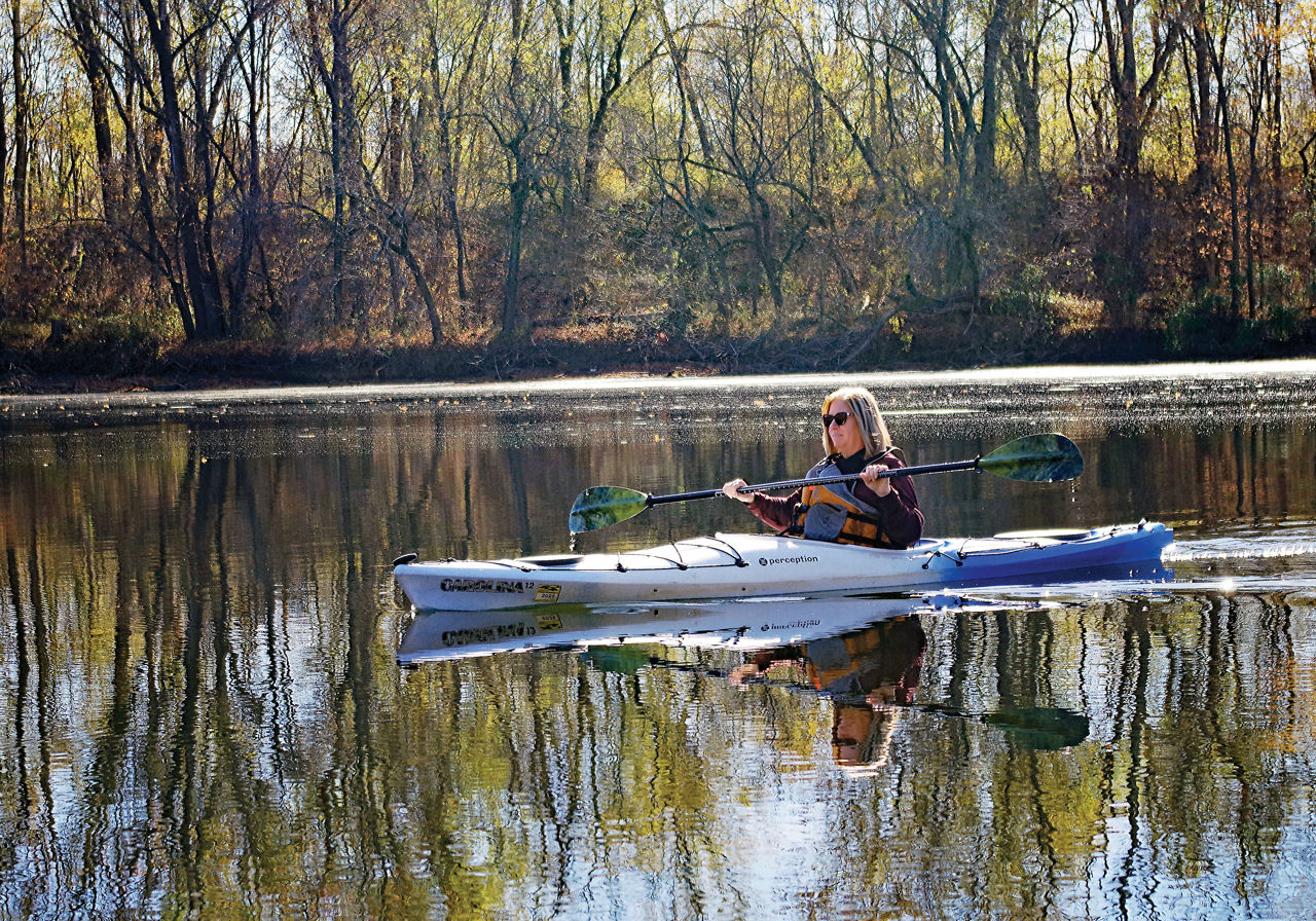 Woman wearing a life jacket paddling a kayak along the Schuylkill River