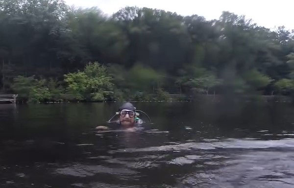 A scuba diver swimming in a lake