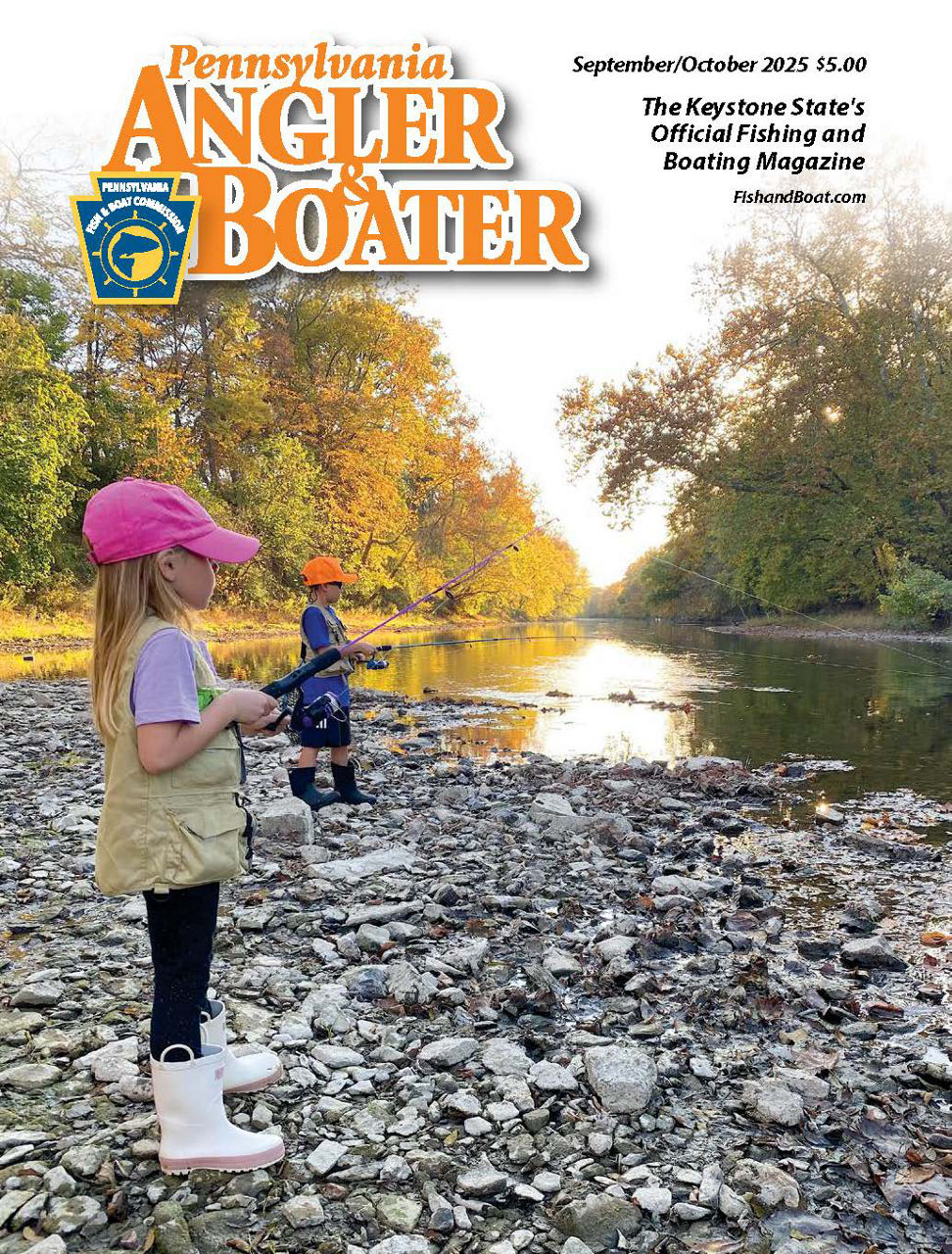 Cover page of the September/October 2025 edition of Angler & Boater Magazine featuring a young girl and young boy fishing along a rocky shoreline of a river with a fall foliage background.