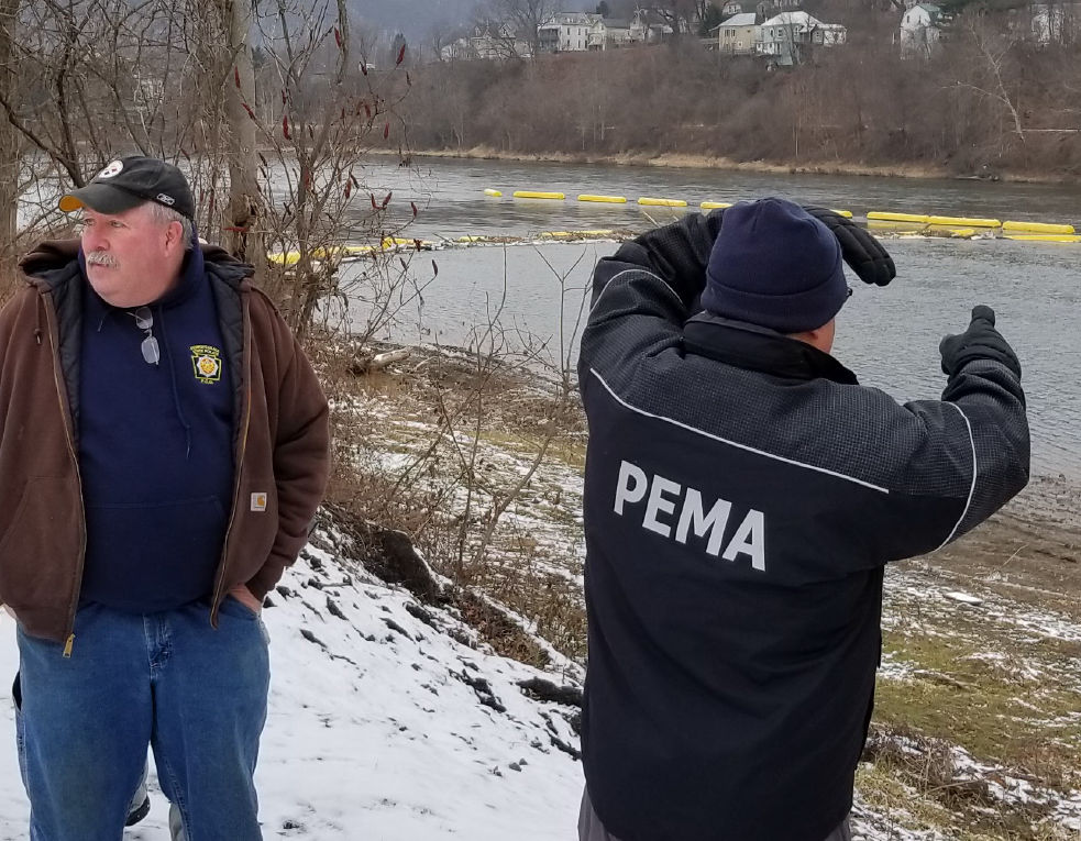 A PEMA hazard mitigation team member surveys a body of water while working with the SIlver Jackets.