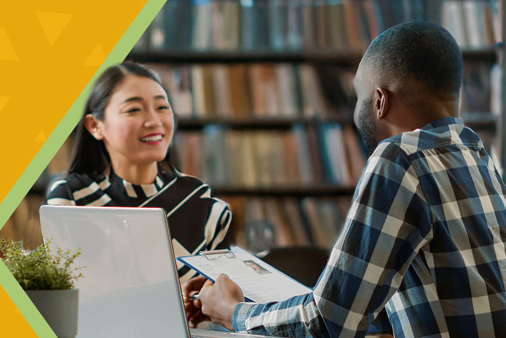 Two adults in a cheery conversation at a library