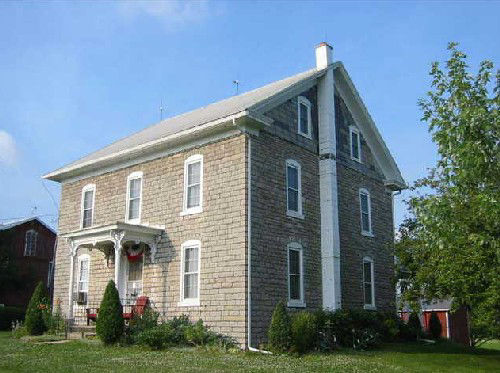Two story house with side gabled roof and three bays across each floor of front façade.