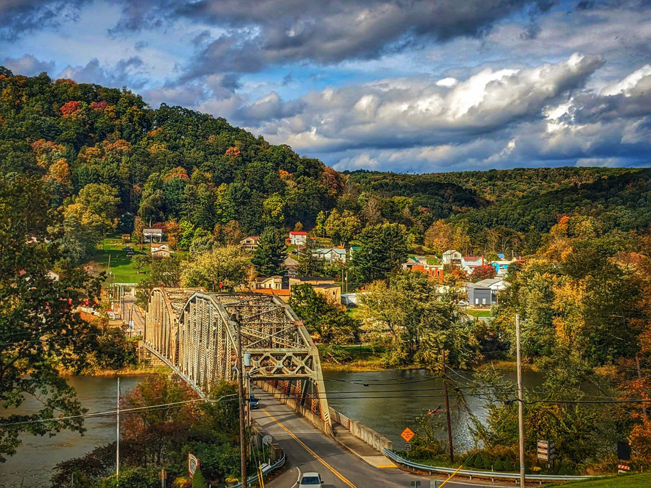 A riverside town nestled among the mountains during autumn.