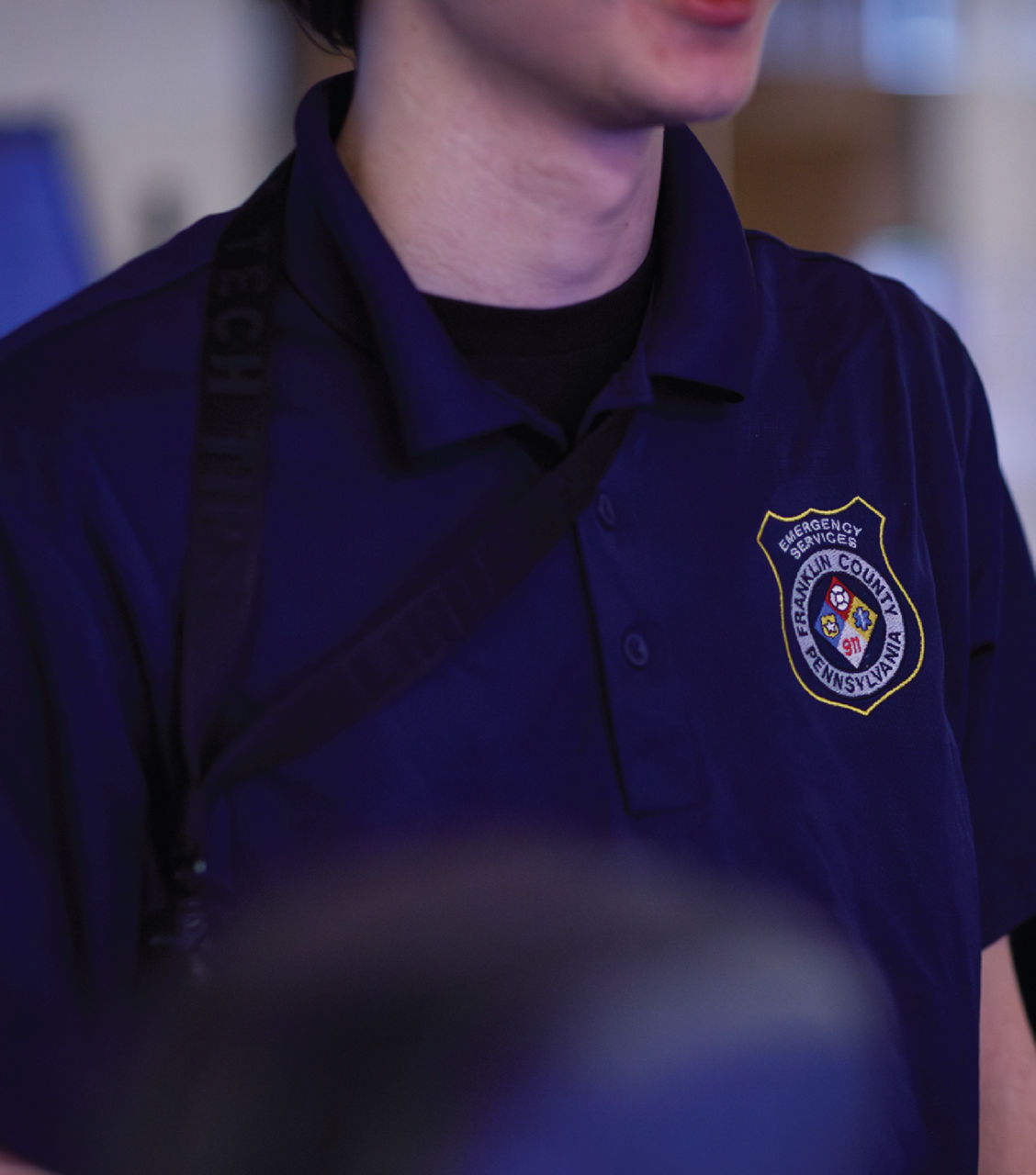 A man wears a county 911 polo.