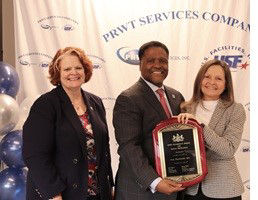 Labor & Industry Secretary stands with U.S. Facilities, Inc. leadership holding a 2025 GASE plaque