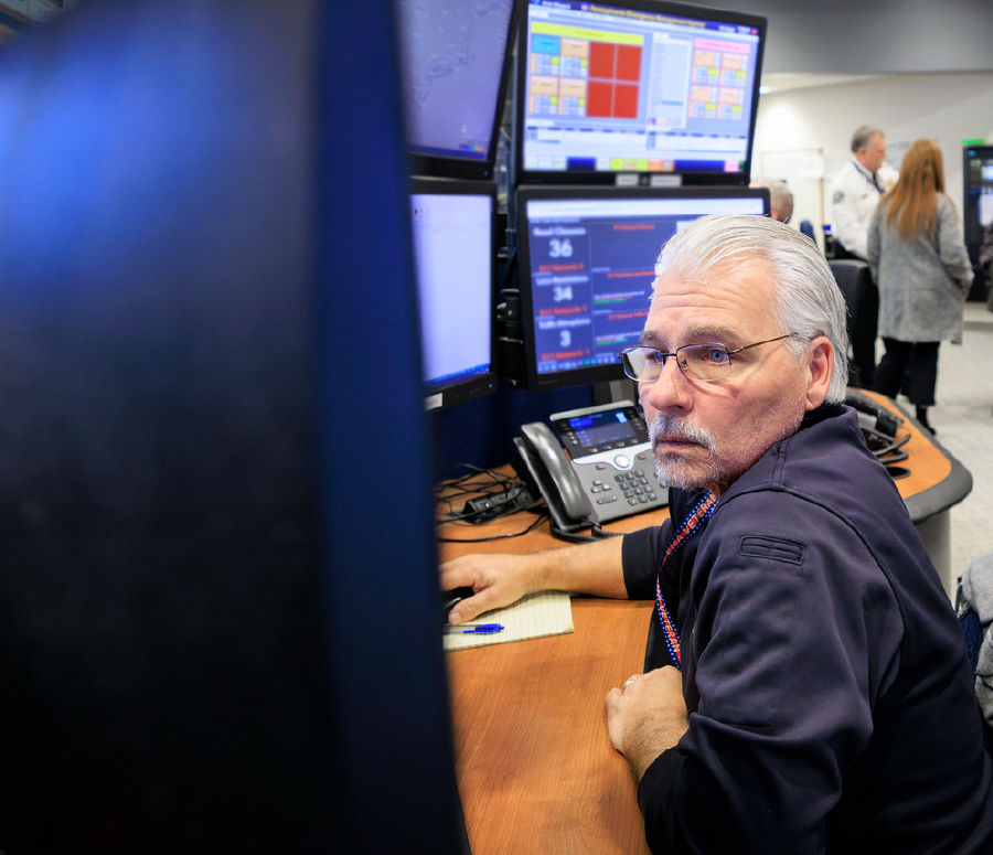 A Watch Officer monitors a bank of screens in the CRCC.