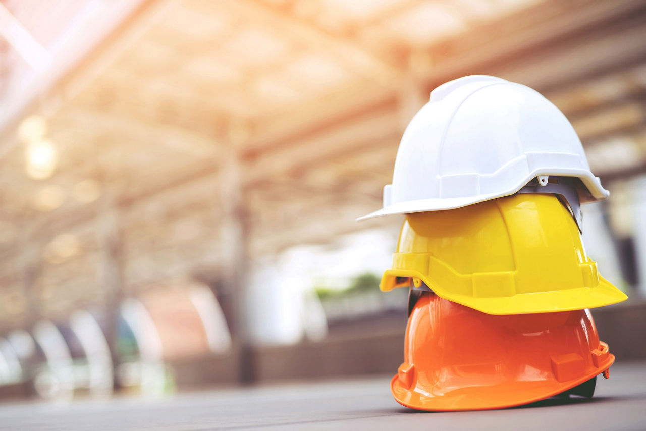 Three construction hard hats stacked upon one another.