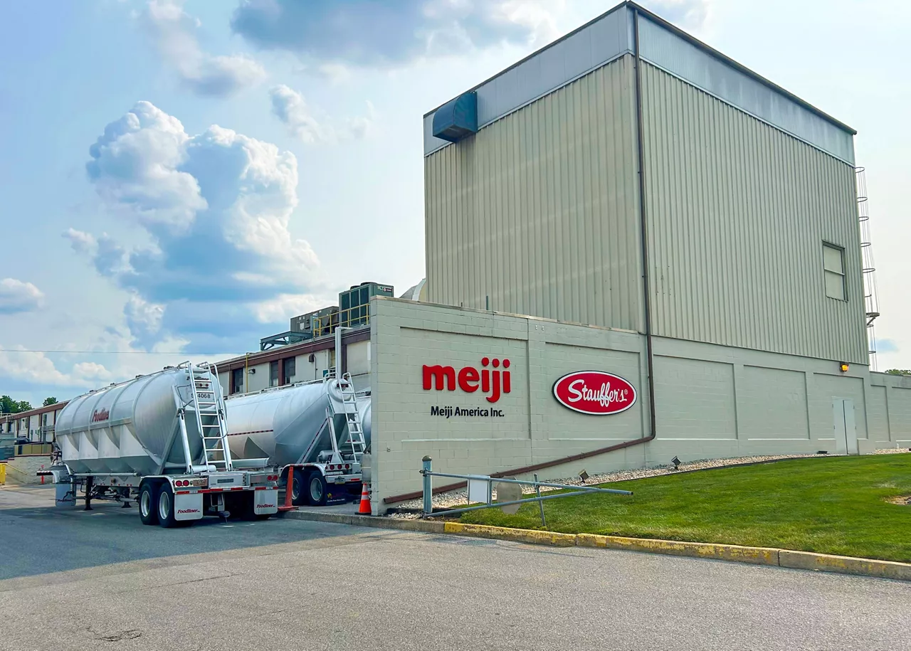 The exterior of Meiji America's snack manufacturing facility in York, Pennsylvania, with trailers parked to the side of the building.