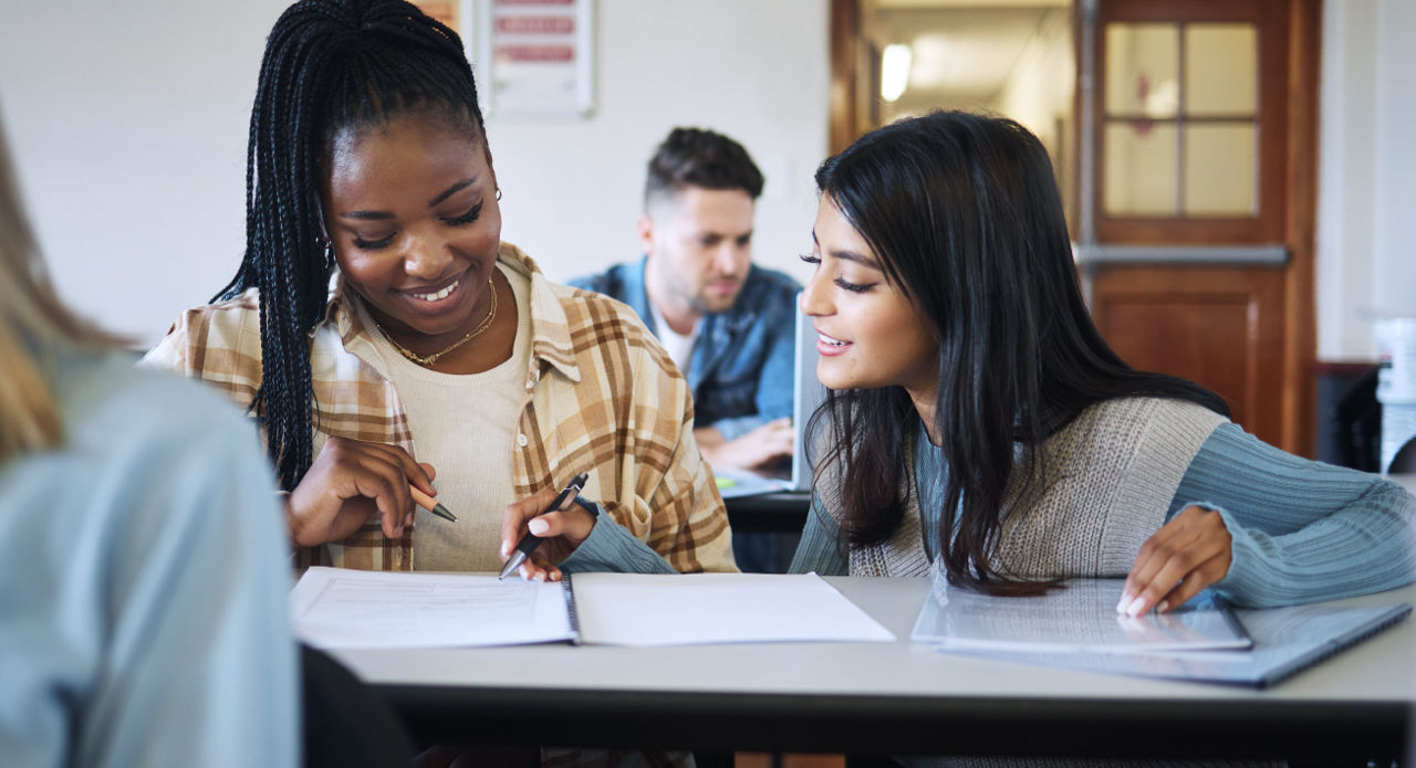 Two young women collaborate on a project.