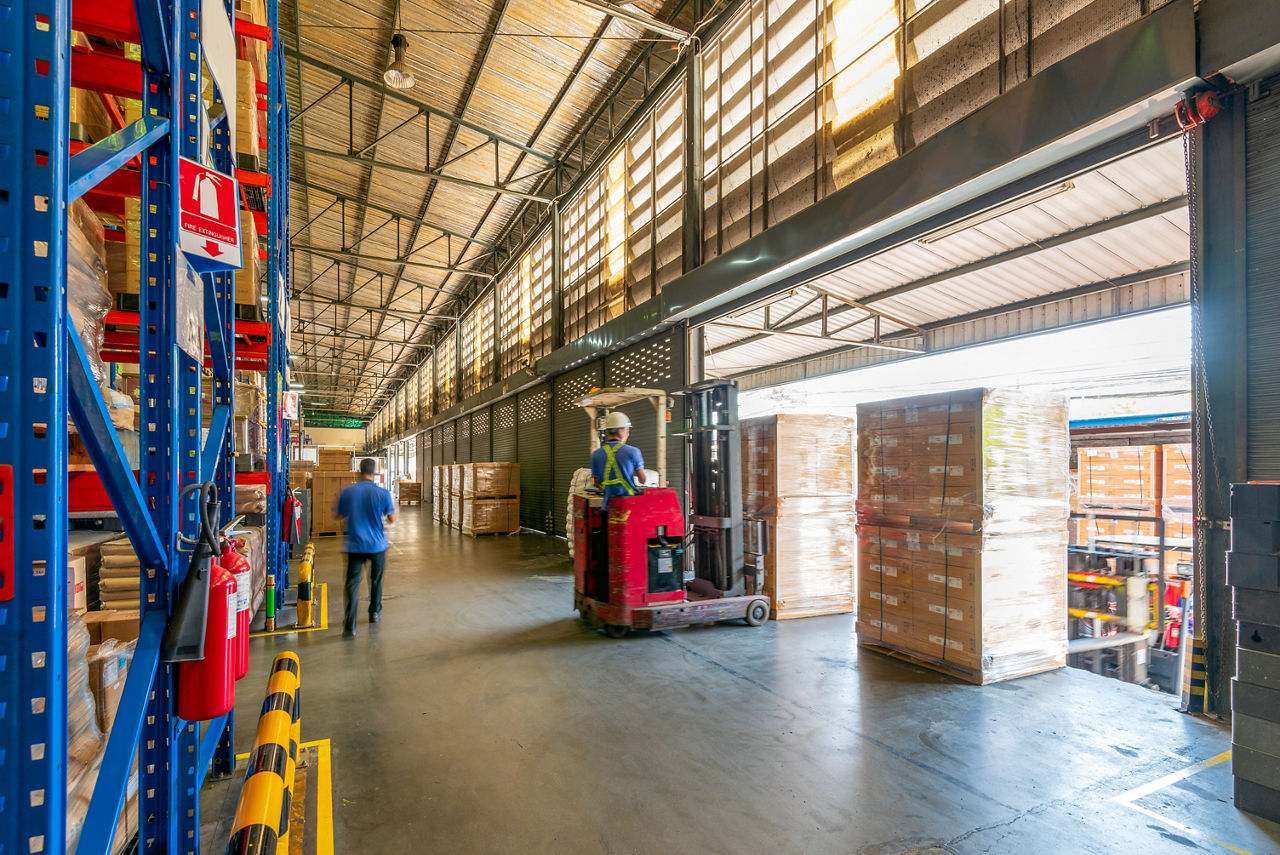 A forklift loads trucks with packages at a shipping and logistics center