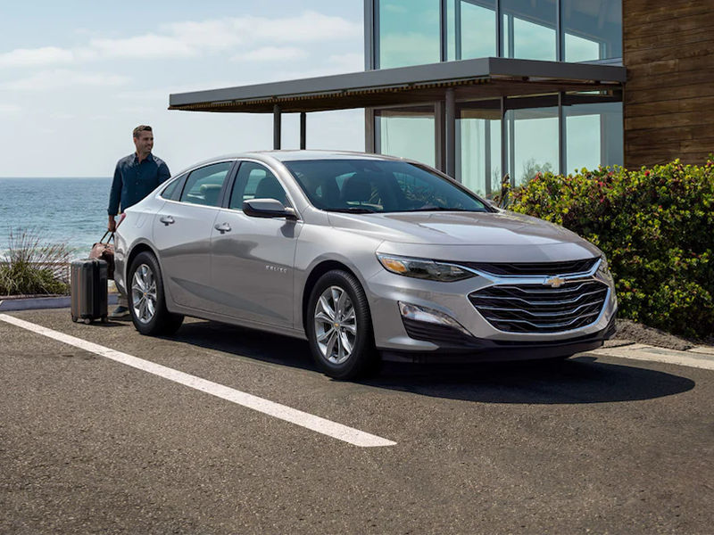 silver chevy malibu parked in seaside parking lot