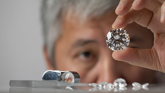 Male jeweler looking at diamond. 