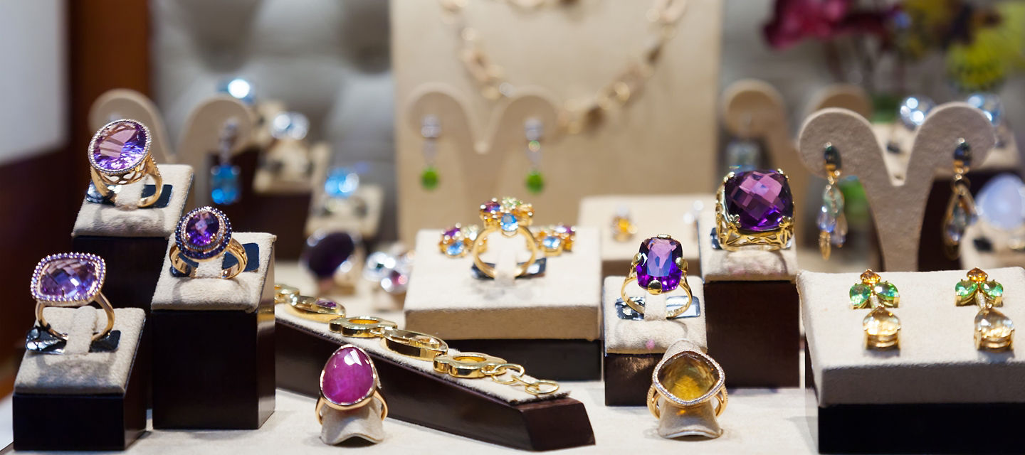 Different gemstone earrings and rings in jewelry display 
