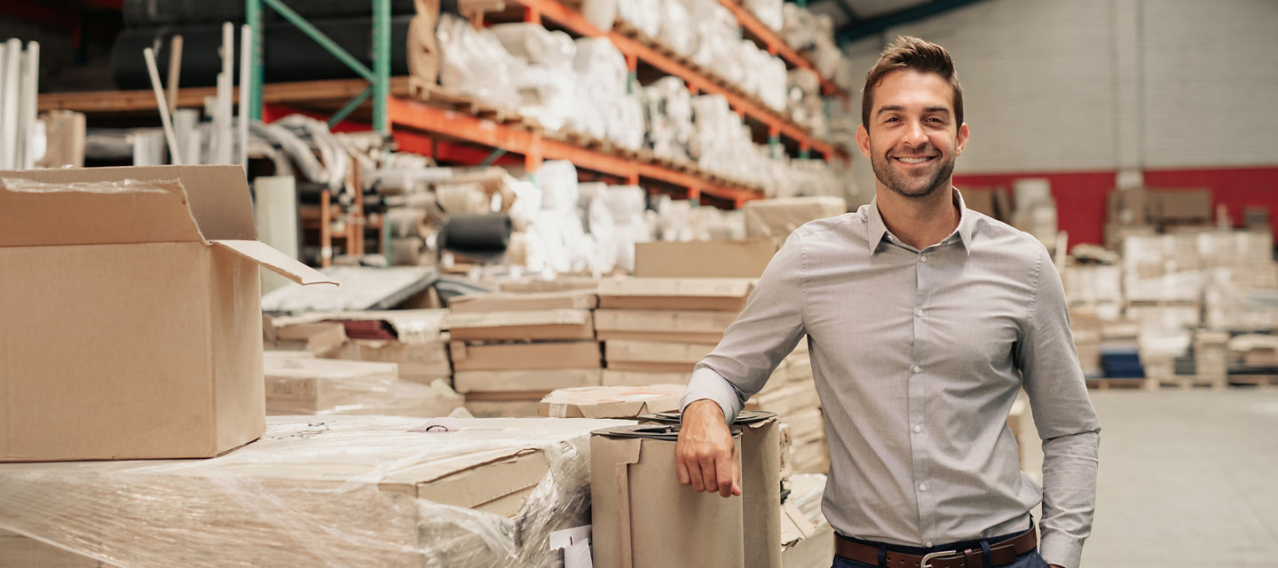 Male leaning on a box in warehouse 
