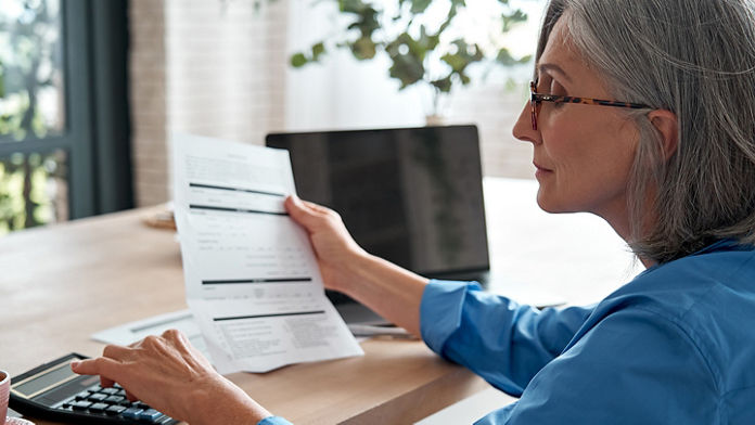 Female using a calculator and looking a paper 