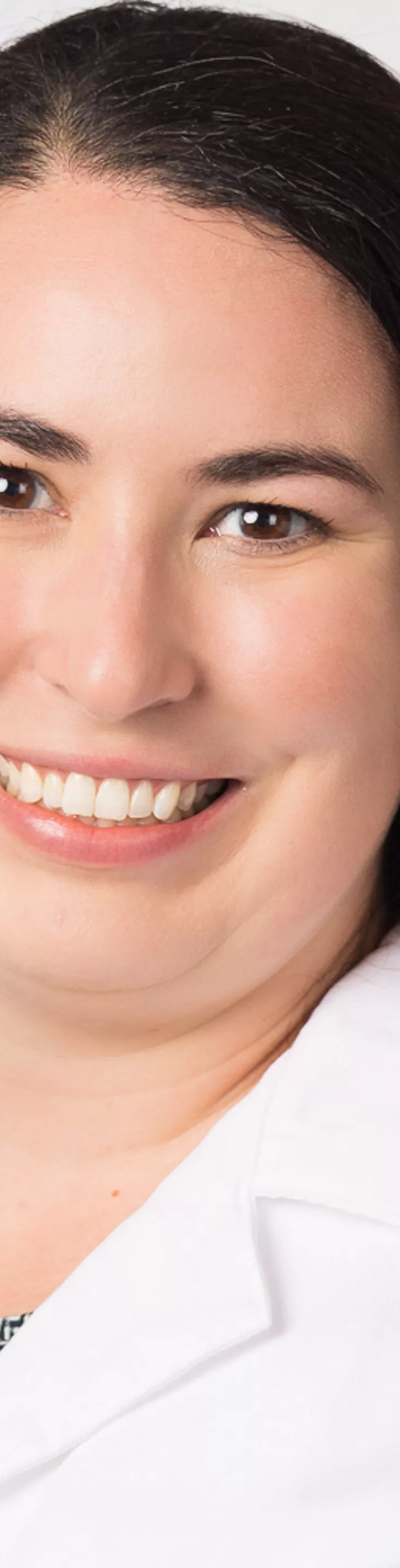 Headshot of Alexandra Guevara. She is wearing a black and white blouse and a white coat.