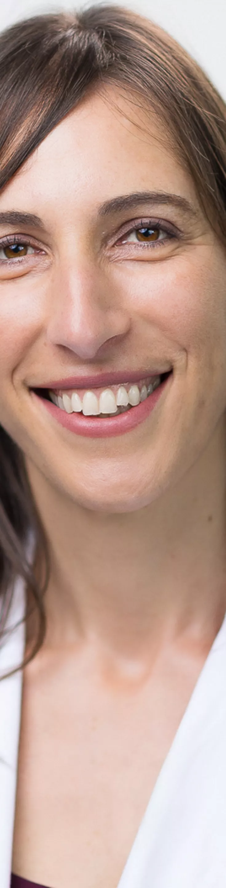 Headshot of Aliza Norwood. She is wearing a purple blouse and a white coat.