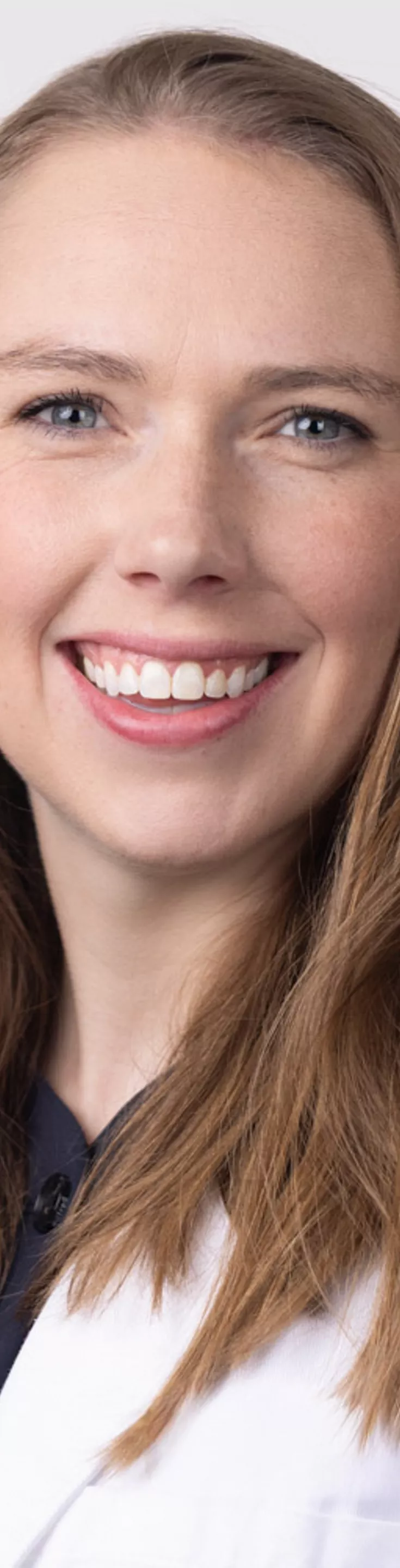 Headshot of Amy Durand. She is wearing a black blouse and a white coat.
