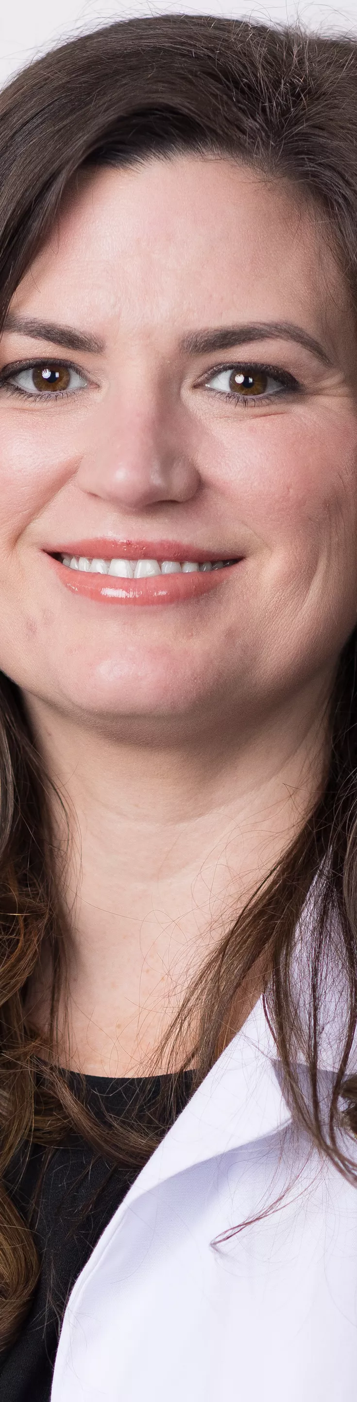 Headshot of Christina Moussette. She is wearing a black blouse and a white coat.