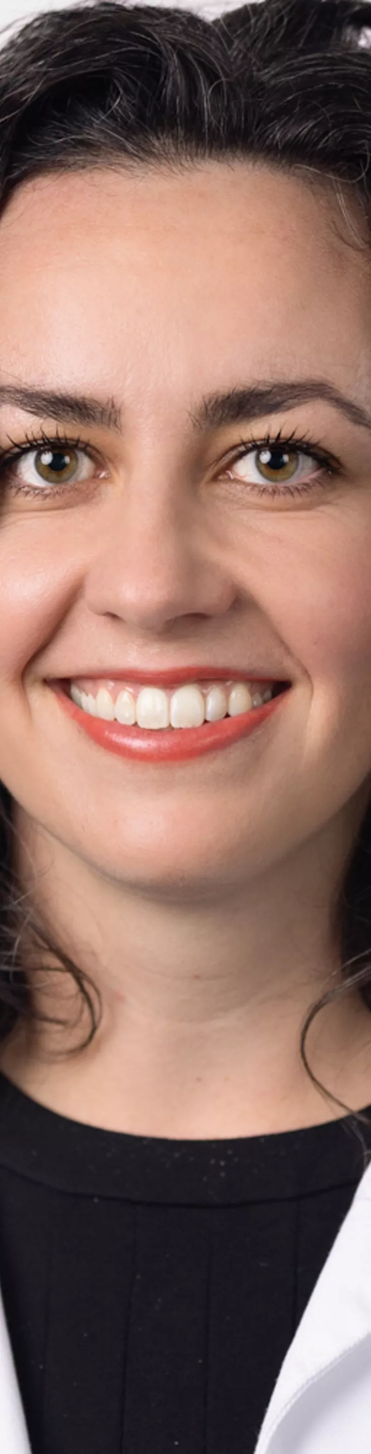Headshot of Claire Harrison. She is wearing a black blouse and a white coat.