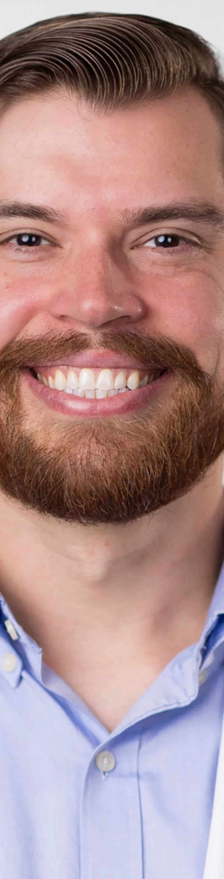 Headshot of David Dalton. He is wearing a blue dress shirt and a white coat.