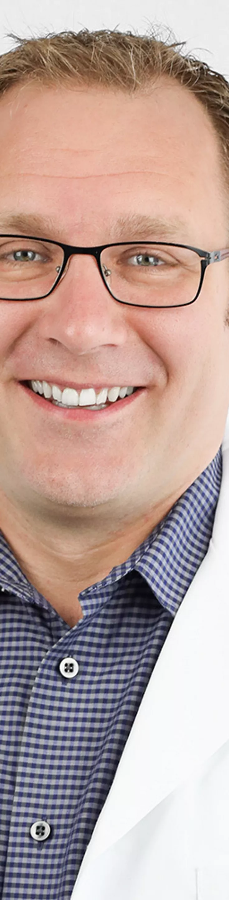 Headshot of Devin Williams.  He is wearing a white coat and a navy dress shirt.
