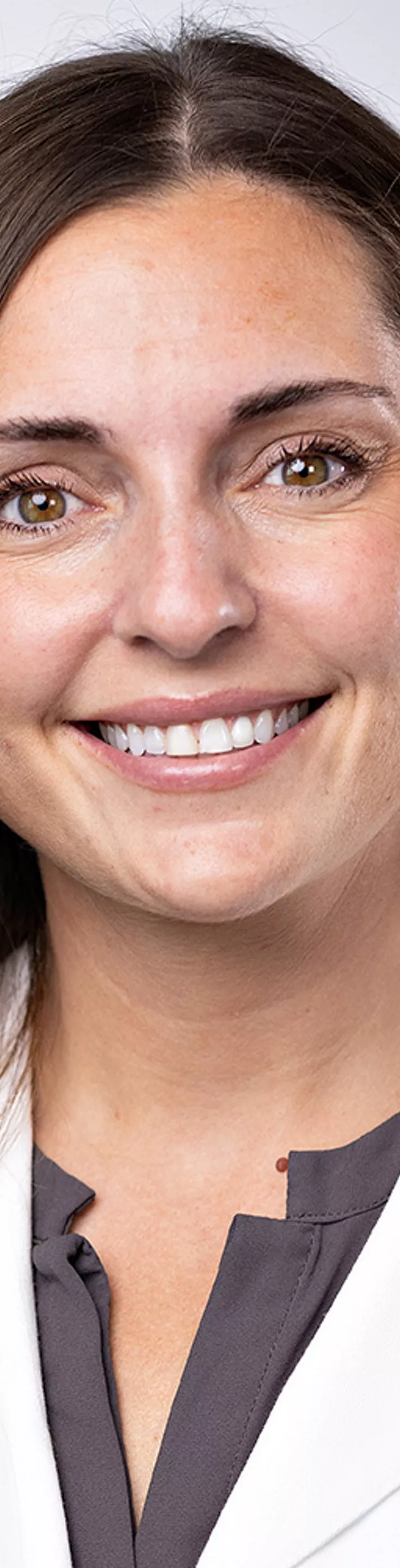 Headshot of Elisa Furay. She is wearing a gray blouse and a white coat.