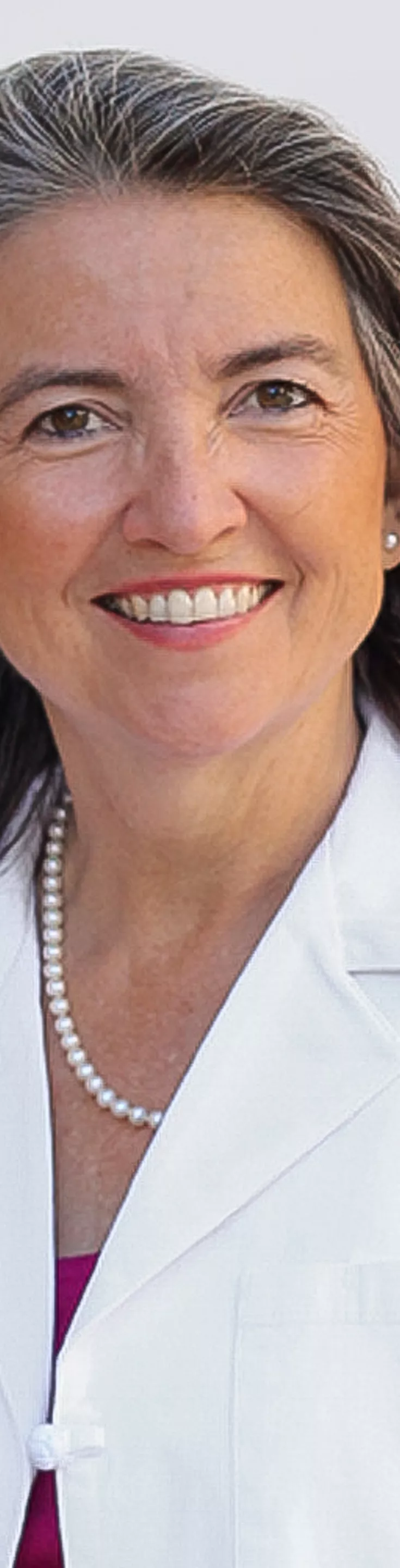 Headshot of Elizabeth Douglass. She is wearing a pink blouse and a white coat.