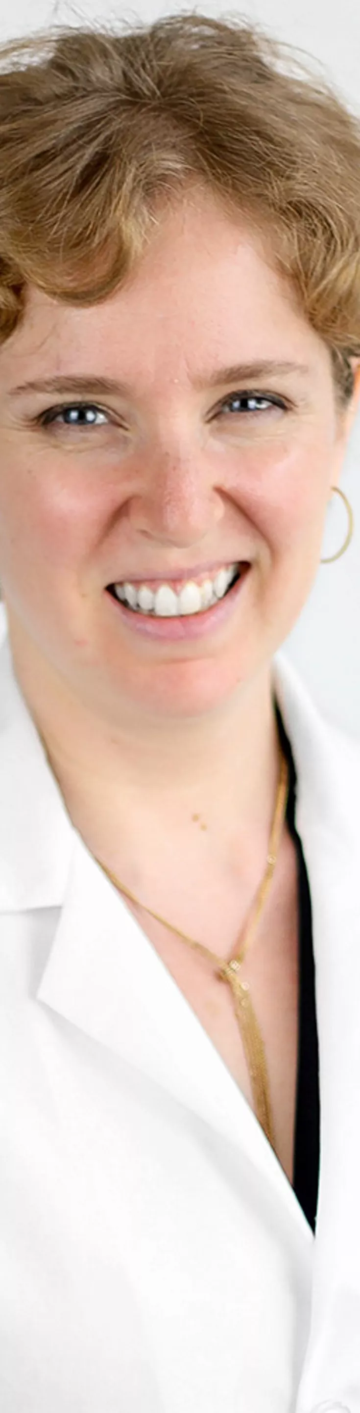 Headshot of Esther Melamed.  She is wearing a white coat and a black blouse.
