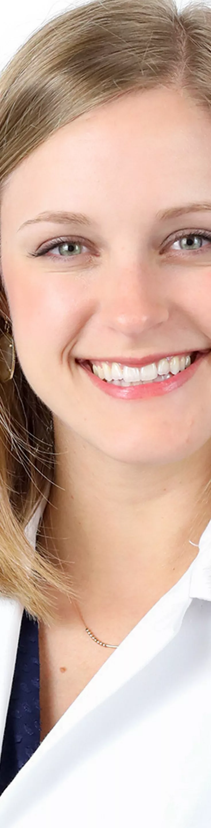 Headshot of Emmy Feeler. She is wearing a white coat and a black blouse.